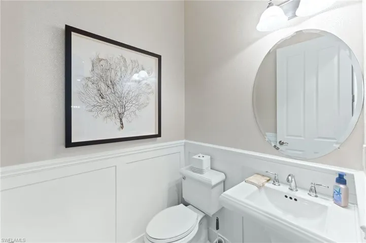 Bathroom featuring a wainscoted wall and a decorative wall