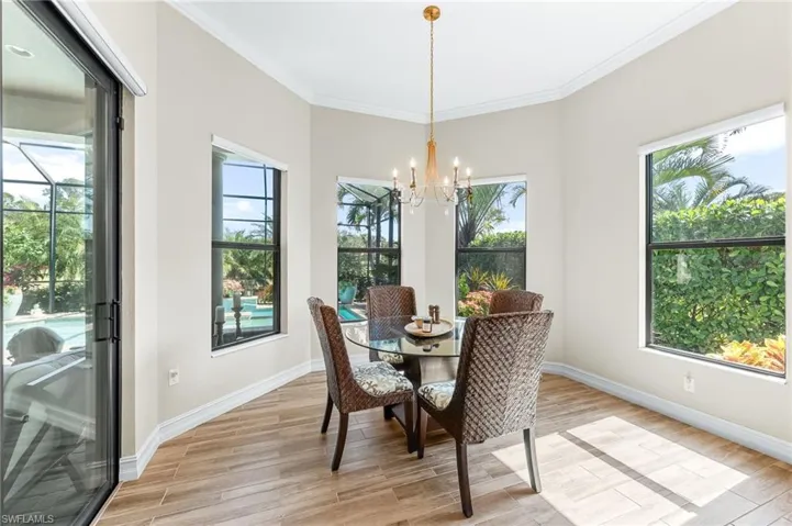 Dining space featuring light wood-style floors, crown molding, and suspended lighting