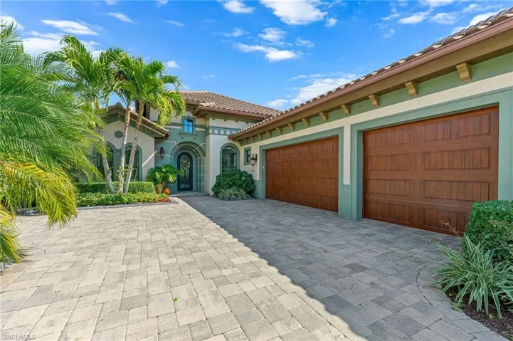 Mediterranean / spanish house featuring a tile roof, stucco siding, and decorative driveway