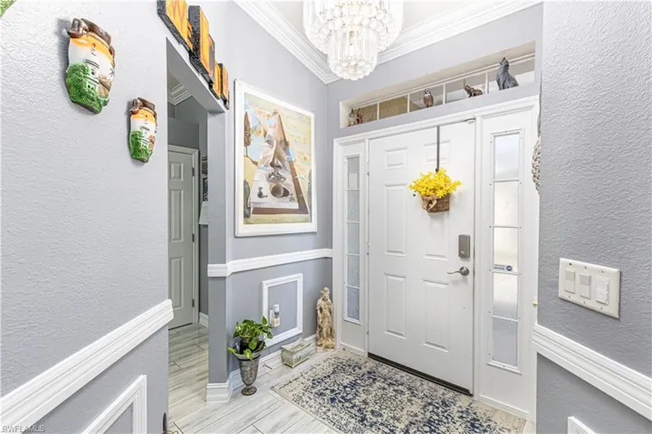 Entrance foyer featuring a chandelier and crown molding