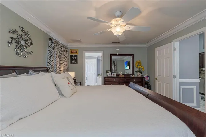 Bedroom with ceiling fan and crown molding