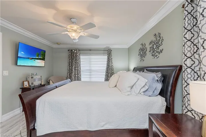 Bedroom featuring ceiling fan, hardwood / wood-style flooring, and ornamental molding