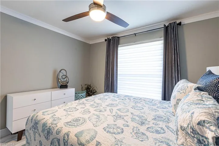 Bedroom with ceiling fan and crown molding
