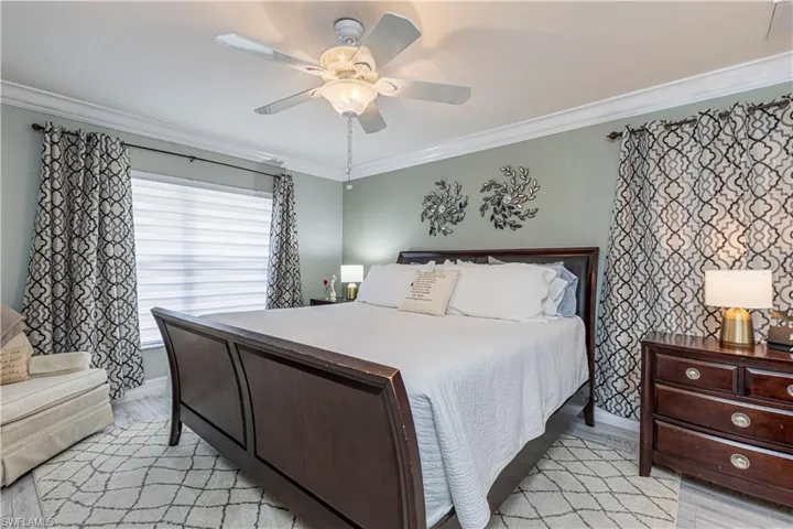 Bedroom featuring ceiling fan, light hardwood / wood-style floors, and ornamental molding