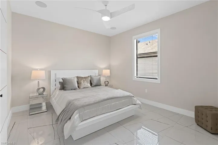 Bedroom with a ceiling fan, baseboards, and marble finish floor