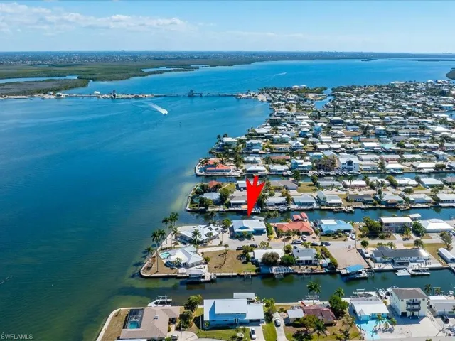 Aerial view of property and surrounding area featuring a large body of water and nearby suburban area