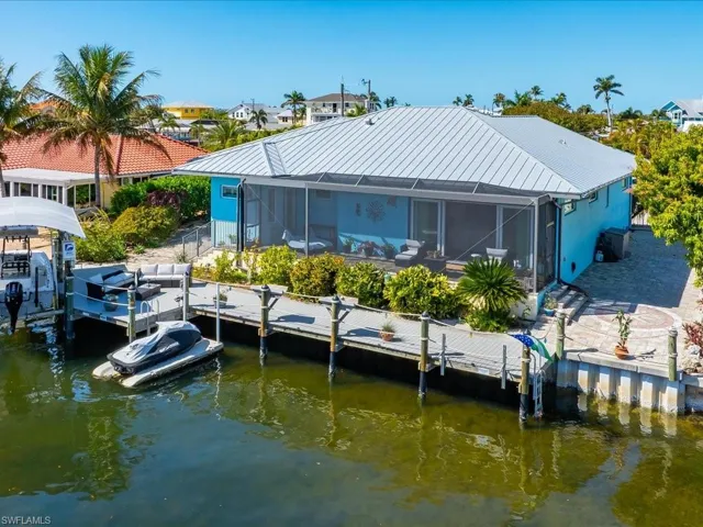 Rear view of property featuring glass enclosure, a water view, and a sunroom