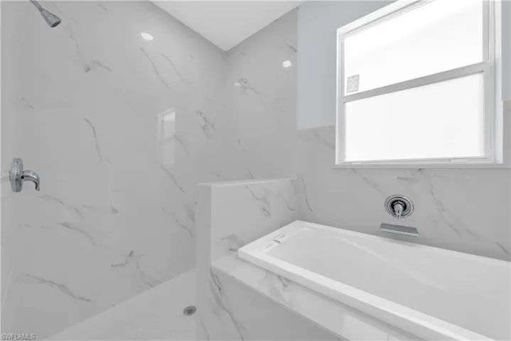 Full bathroom with a garden tub and a marble finish shower