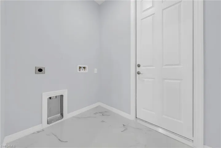 Washroom with light marble finish flooring, hookup for a washing machine, and hookup for an electric dryer