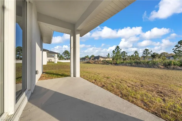 View of grassy yard with a patio area