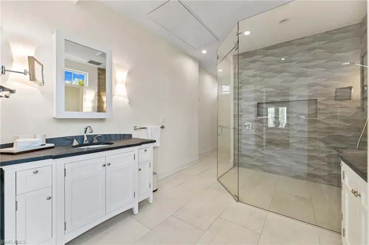 Full bathroom with vanity, visible vents, recessed lighting, a stall shower, and baseboards