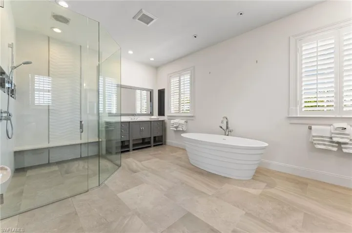 Full bath with vanity, a stall shower, a soaking tub, recessed lighting, and visible vents