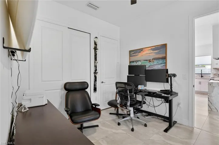Interior room with light gray tile flooring, white walls, and a ceiling fan
