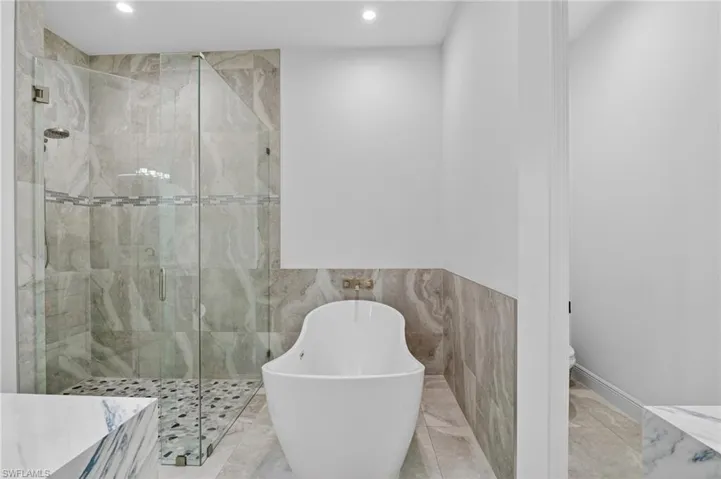 Contemporary bathroom featuring a freestanding tub and a glass-enclosed shower