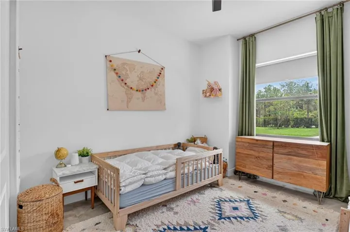 Bright room with a large window, light wood-finish flooring, and white walls
