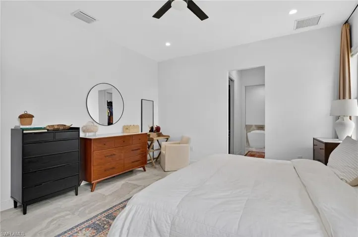 Spacious room featuring light-toned tile flooring, recessed lighting, and a dark-toned ceiling fan
