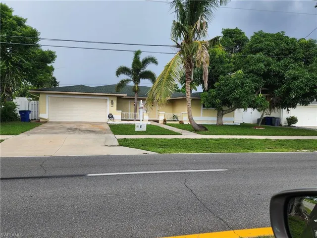 Single story home featuring a garage and a front lawn