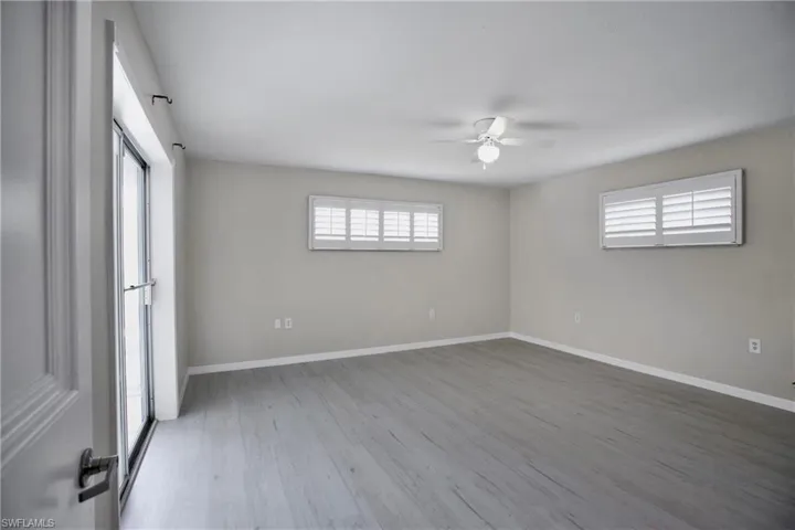 Owners Primary Bedroom with wood-type flooring and ceiling fan