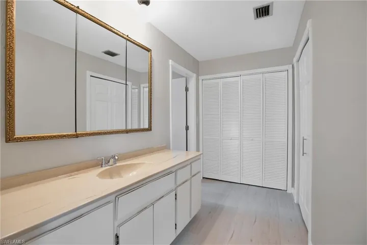 Owners Dressing Area featuring vanity and wood-type flooring