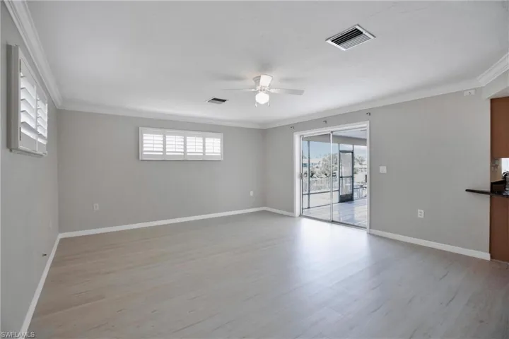 Dining Rm / Den 2nd view with crown molding, light wood-type flooring, ceiling fan, and a wealth of natural light