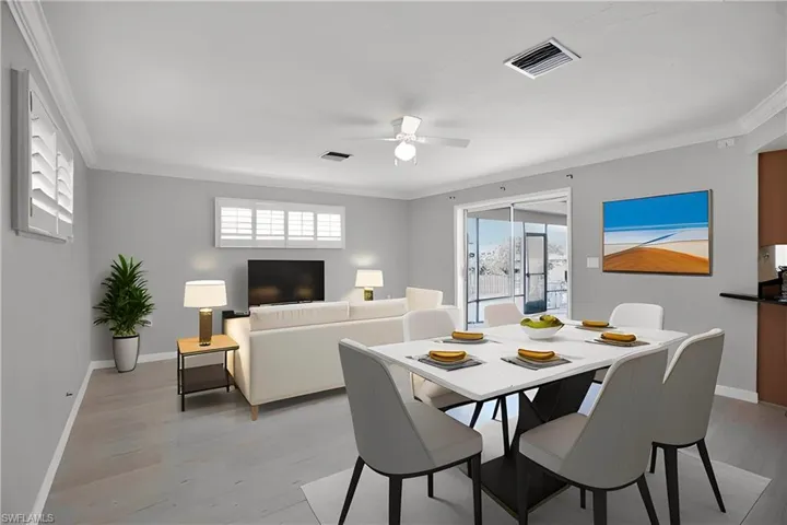 Dining area with light hardwood / wood-style flooring, ceiling fan, and crown molding