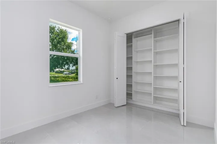 Crisp white walls frame a single pane window, complemented by light gray tile flooring