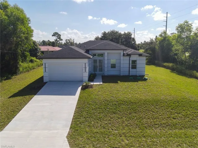 Modern architecture featuring a dark shingle roof, attached garage, white exterior walls, and a concrete driveway