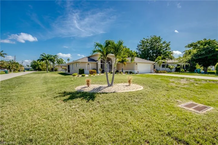 Ranch-style house featuring driveway, a front yard, an attached garage, and stucco siding