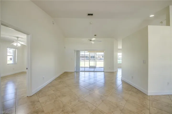 Unfurnished room featuring ceiling fan, high vaulted ceiling, and light tile patterned floors