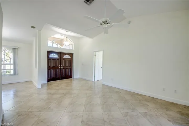 Entrance foyer featuring high vaulted ceiling and a ceiling fan