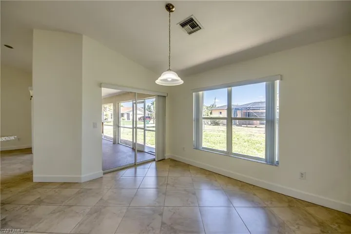 Unfurnished room with vaulted ceiling and light marble finish floors