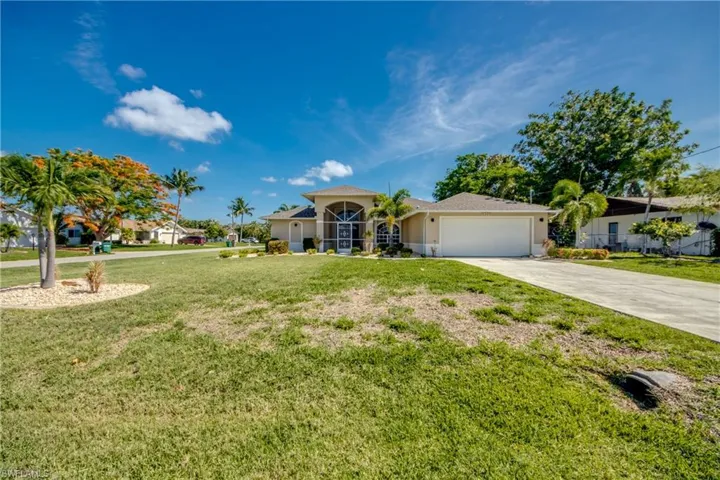 View of front of home with a garage, driveway, stucco siding, and a front yard