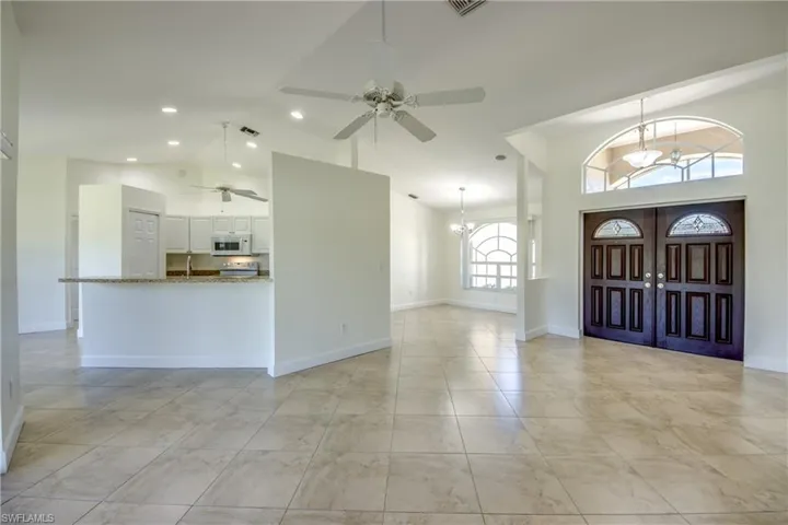 Foyer entrance with a ceiling fan, high vaulted ceiling, recessed lighting, and a chandelier