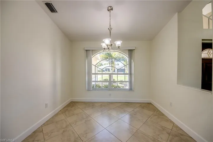 Spare room featuring a chandelier and tile patterned floors