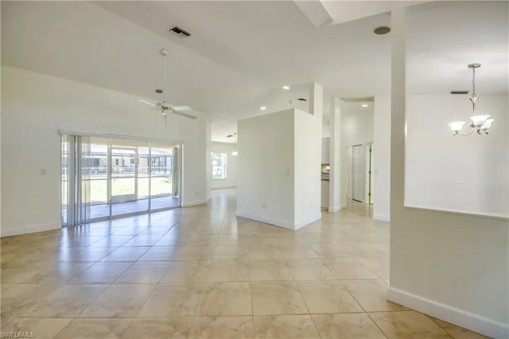 Unfurnished room featuring ceiling fan, high vaulted ceiling, a chandelier, and recessed lighting