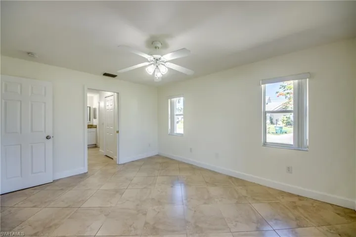 Unfurnished bedroom with ceiling fan and ensuite bathroom