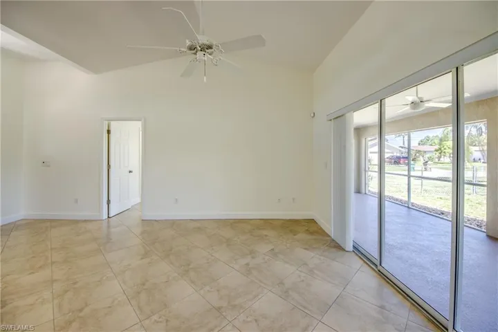 Unfurnished room featuring a ceiling fan and high vaulted ceiling