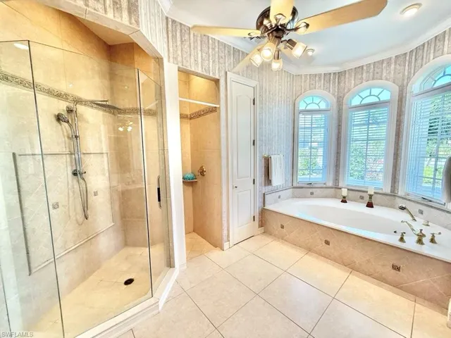 Bathroom featuring crown molding, ceiling fan, tile patterned floors, and plus walk in shower