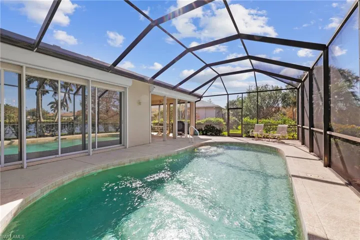 View of swimming pool with a patio and screen enclosure
