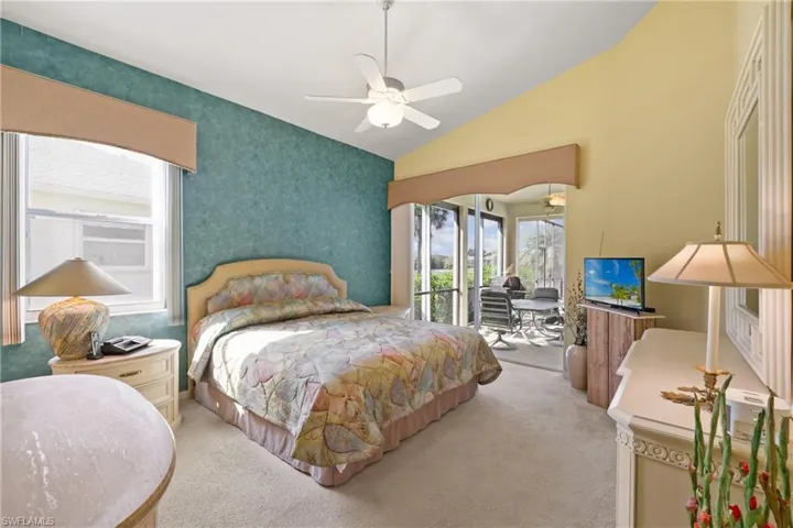 Carpeted bedroom with lofted ceiling, access to exterior, and ceiling fan
