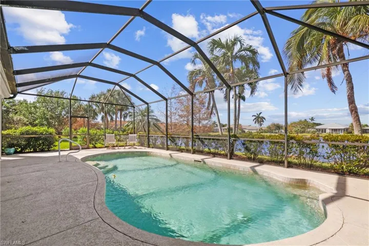 View of swimming pool with a water view, a patio, and screen enclosure
