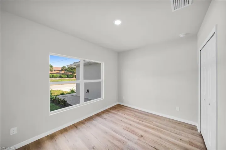 Unfurnished bedroom with light wood-style floors, a closet, visible vents, and baseboards