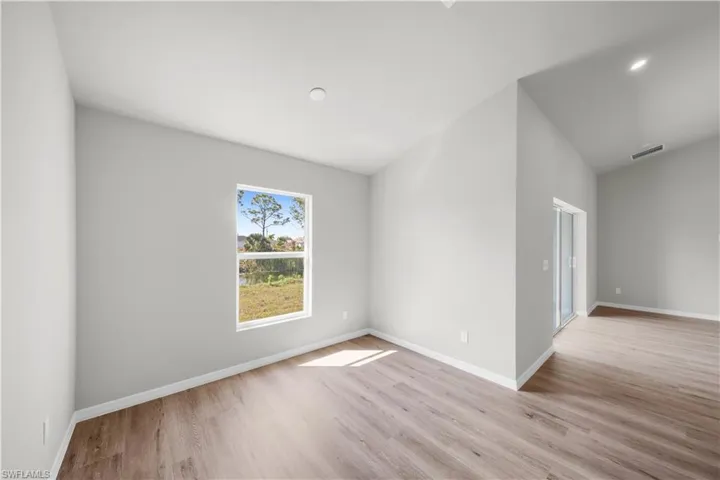 Unfurnished room with light wood-style floors, visible vents, and baseboards