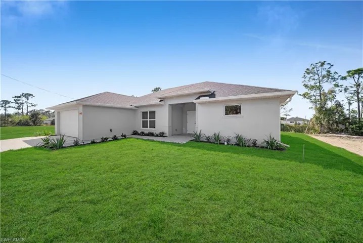View of front of property featuring roof with shingles, stucco siding, a front yard, a garage, and driveway