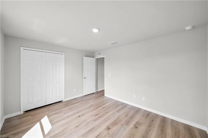 Unfurnished bedroom with light wood-style floors, baseboards, and visible vents