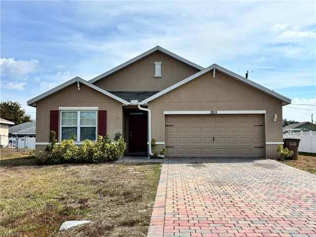 Ranch-style house with stucco siding, decorative driveway, and a garage