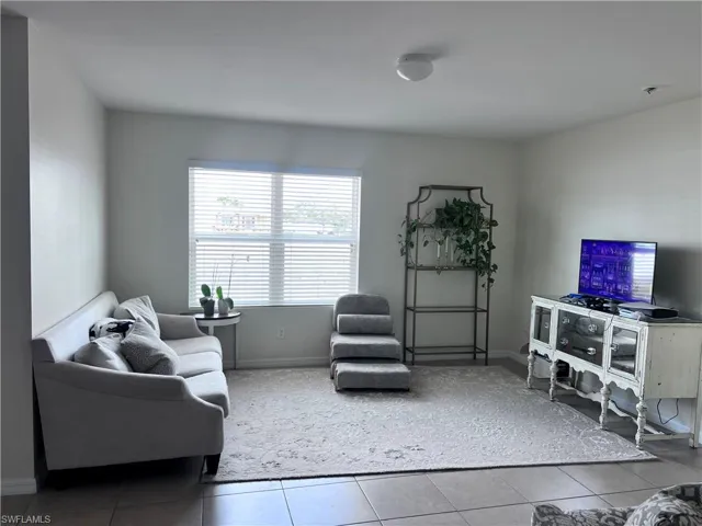Living room featuring light tile patterned floors and baseboards