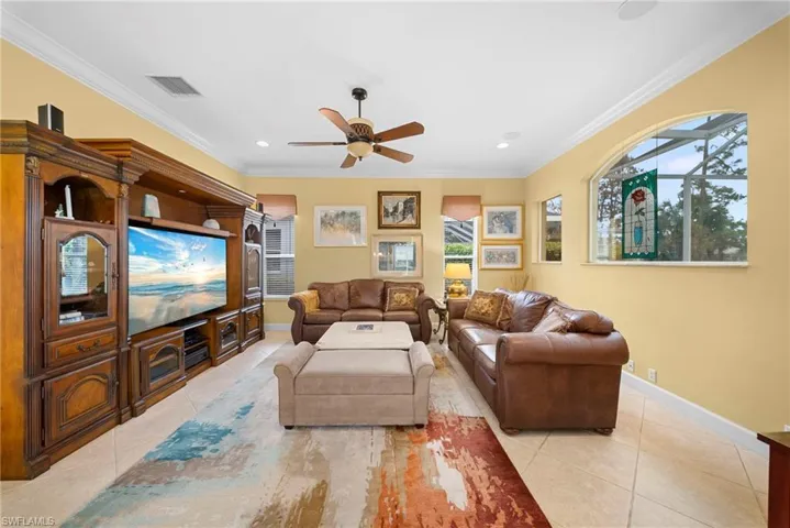 Living area with a ceiling fan, crown molding, light tile patterned floors, and recessed lighting