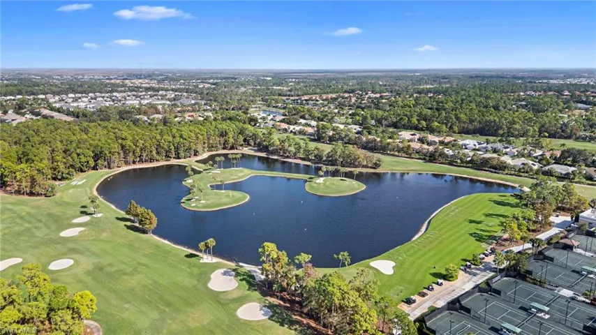 Aerial view of property and surrounding area featuring nearby suburban area and a nearby body of water