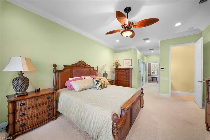Bedroom featuring a closet, ensuite bath, recessed lighting, light carpet, and ornamental molding